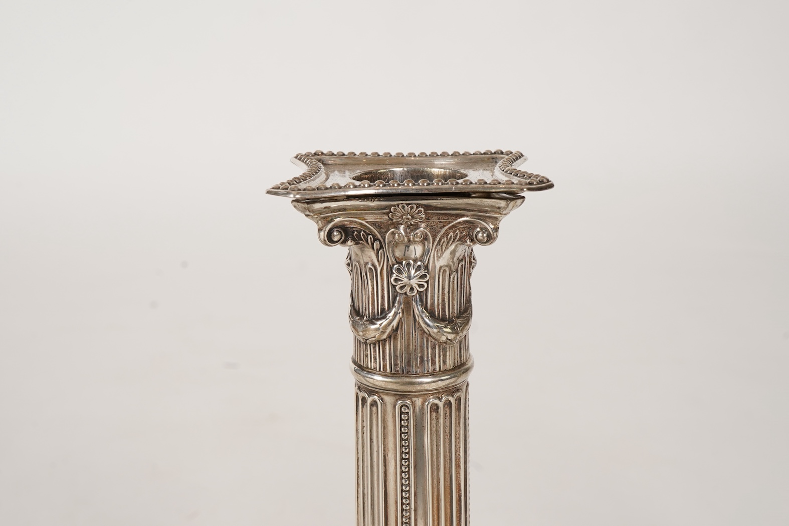 A set of four George III silver corinthian column candlesticks, by John Winter & Co